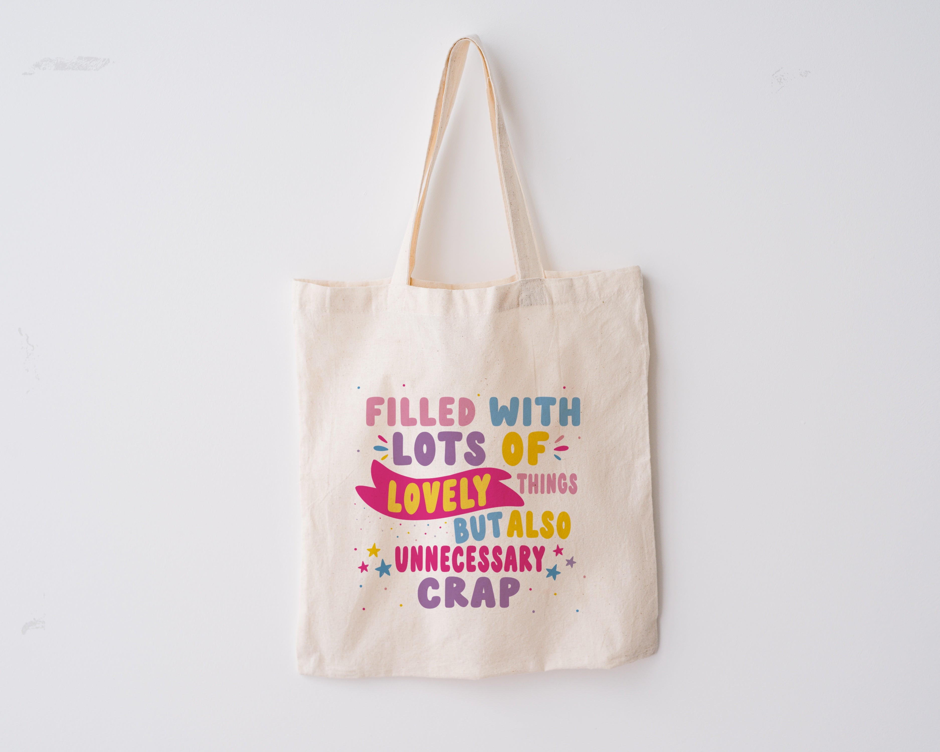 Tote Bag, with the quote "Filled with Lots of Lovely Things but Also Unnecessary Crap" in pink, purple, blue and yellow writing