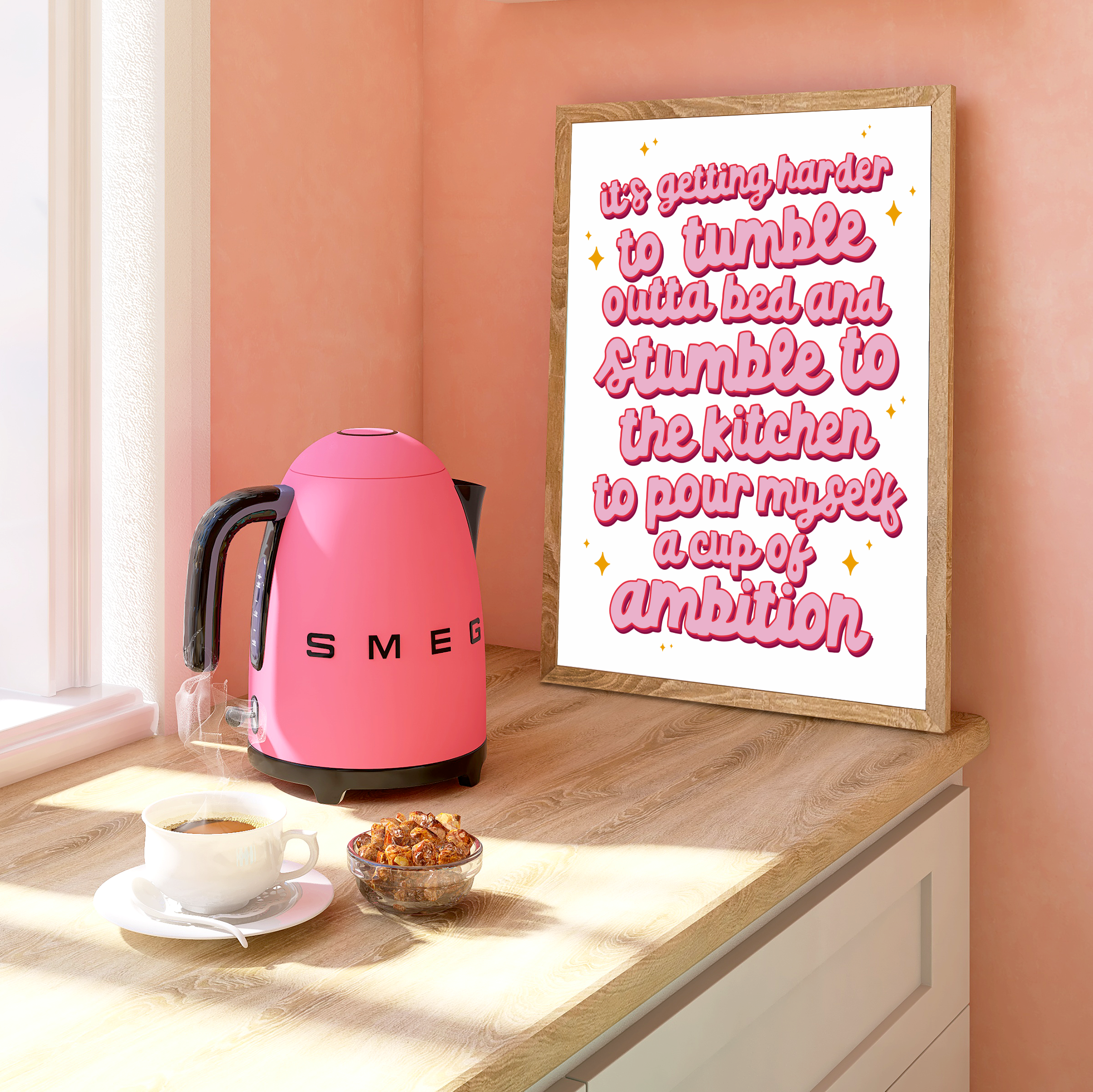 "Framed print: 'It's Getting Harder to Tumble Out of Bed and Stumble to the Kitchen, to Pour Myself a Cup of Ambition.' Crisp white backdrop, pink cursive typography."