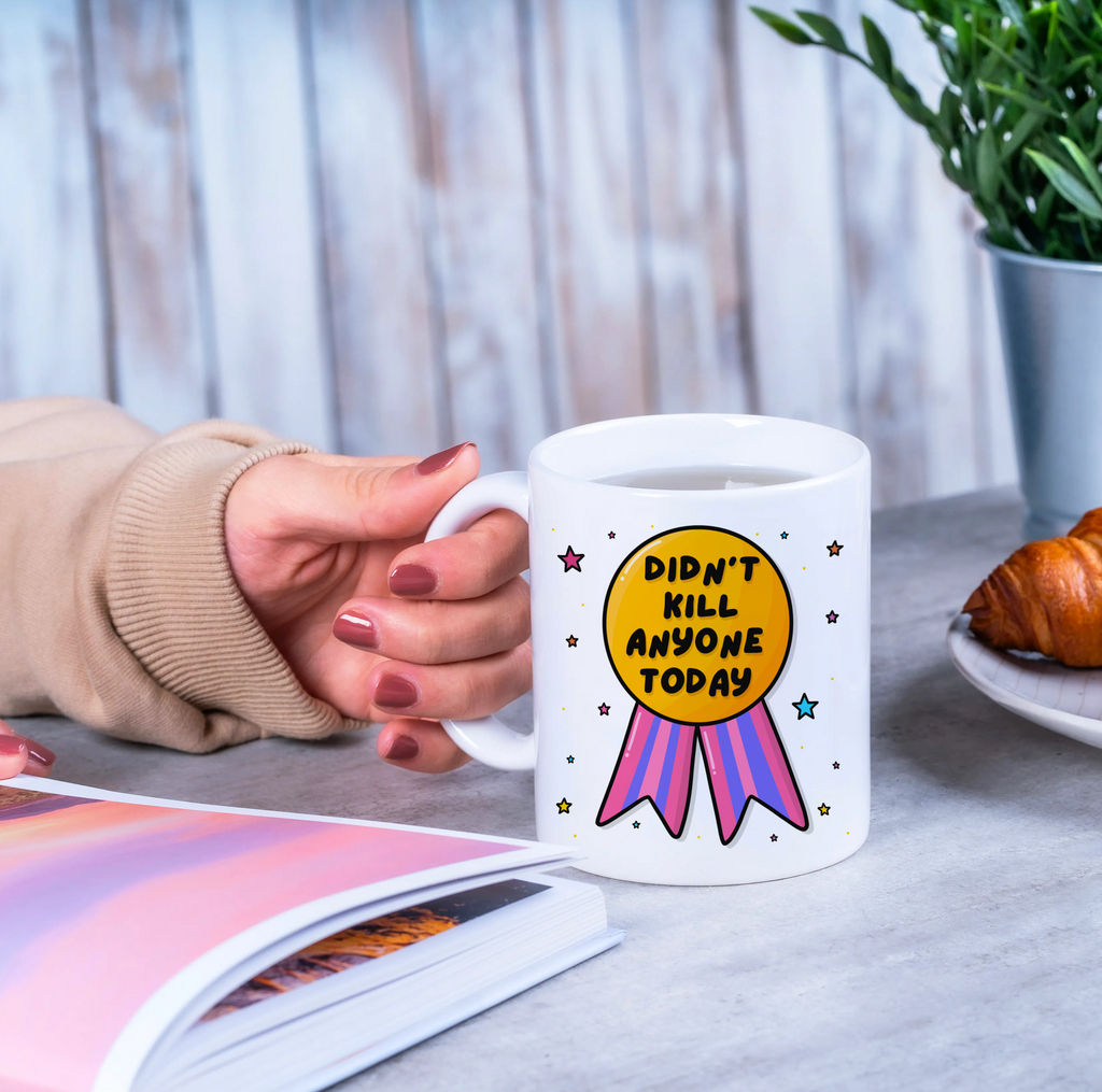 "Cheerful mug holder showcasing the 'Didn't Kill Anyone Today' message with a medal illustration."
